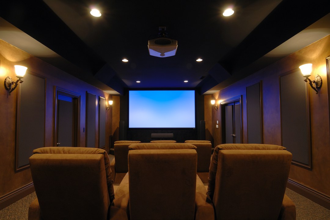 Home cinema room with symmetrical lighting and ceiling projector.