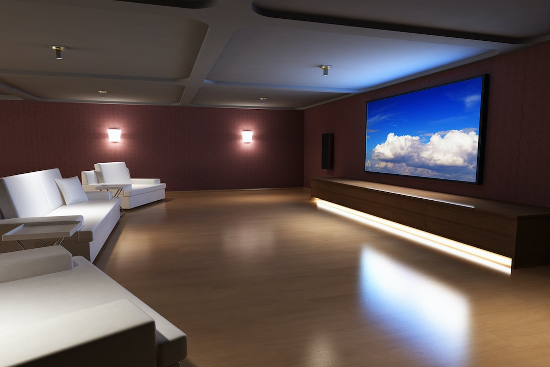 Home theater with wooden floor and white seats.